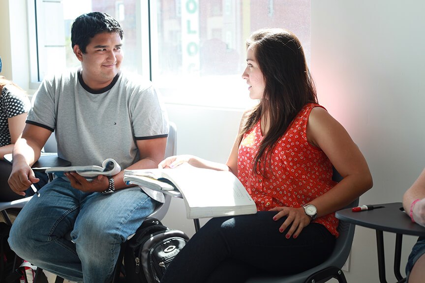 Two learners practice classroom conversation