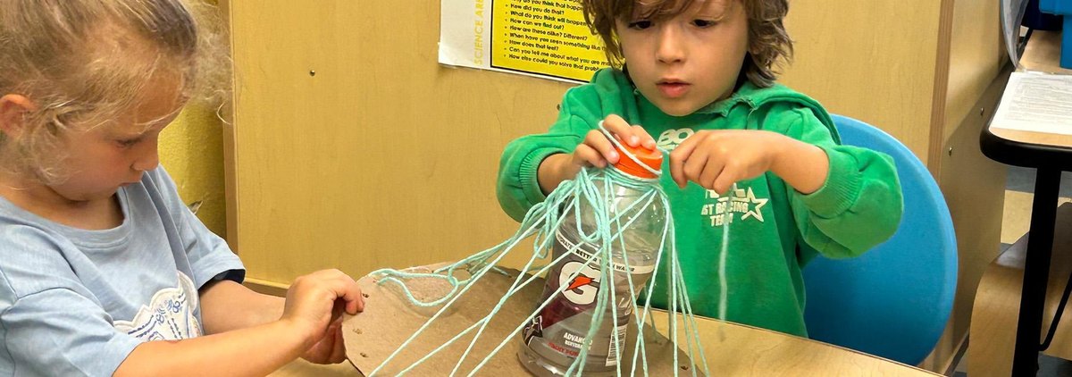 Children make a science craft with a bottle, cardboard and yarn