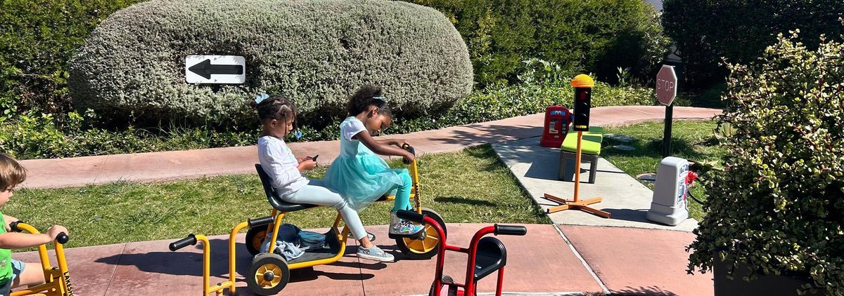 Children ride and play in the preschool outdoor area