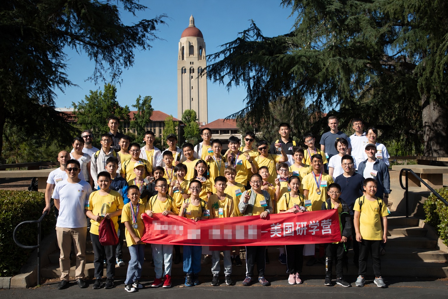 Students in matching program shirts; banner branding has been pixelated